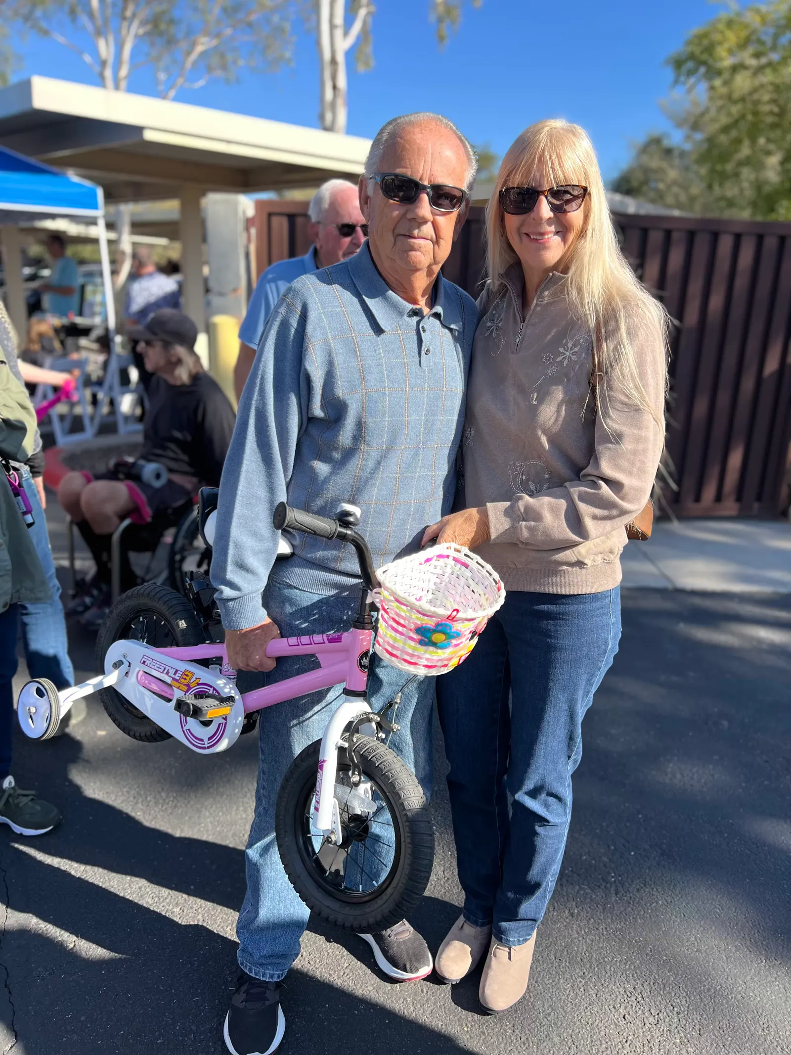 A couple standing with a child's bicycle and helmet