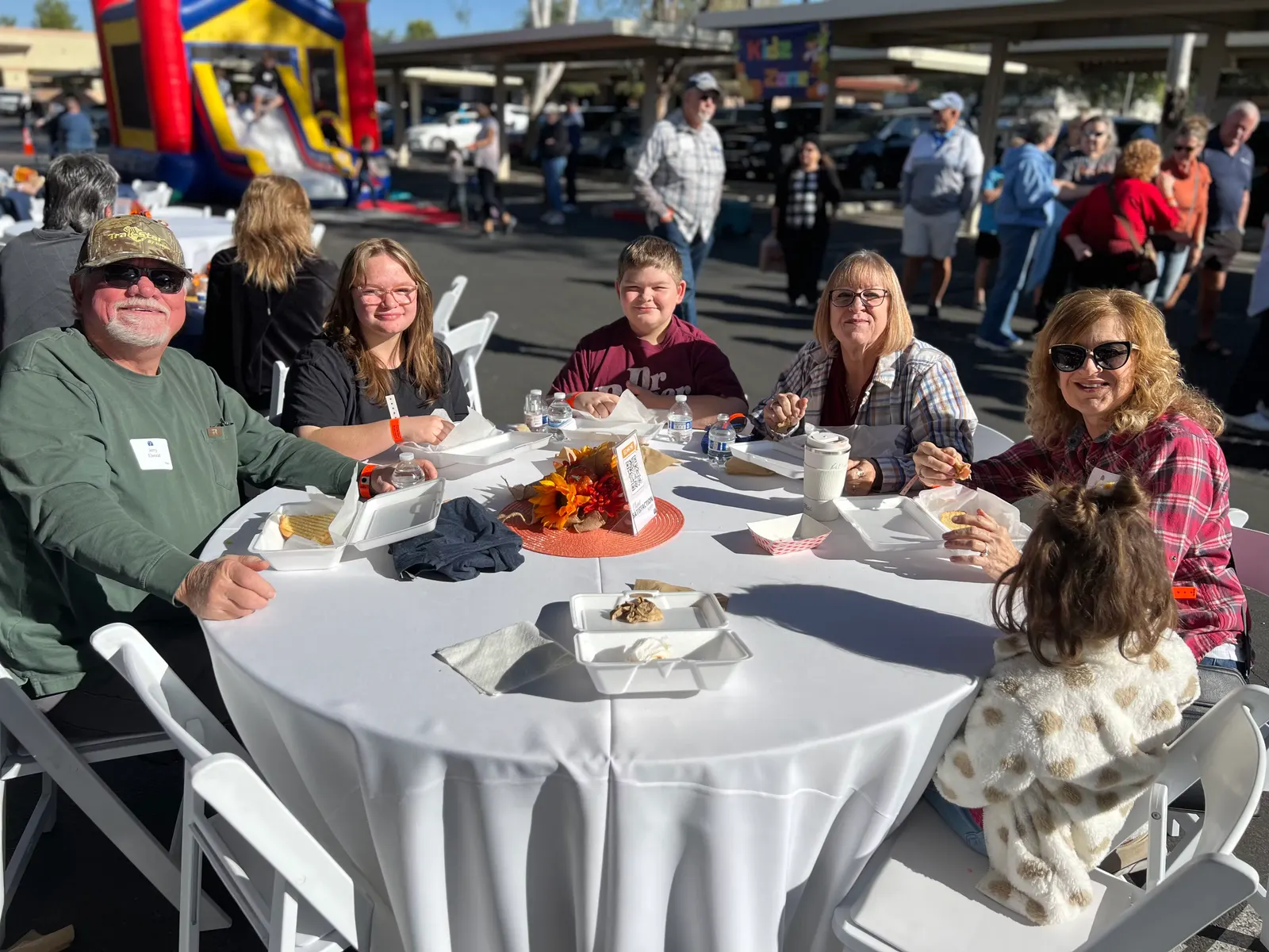 A family eating together at a round table under the canopy