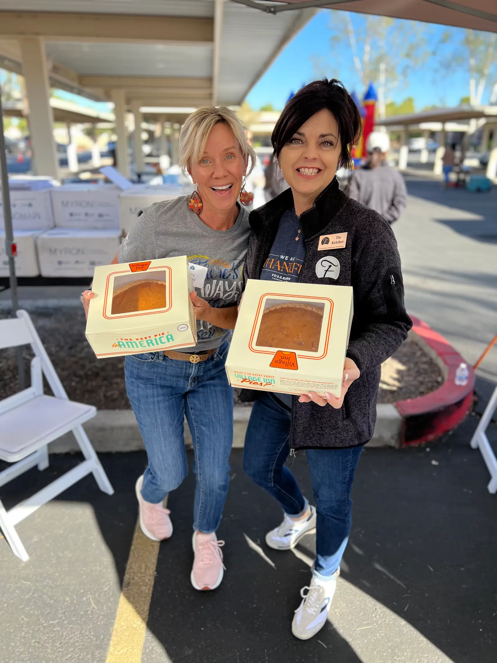 Two people holding boxes of pie
