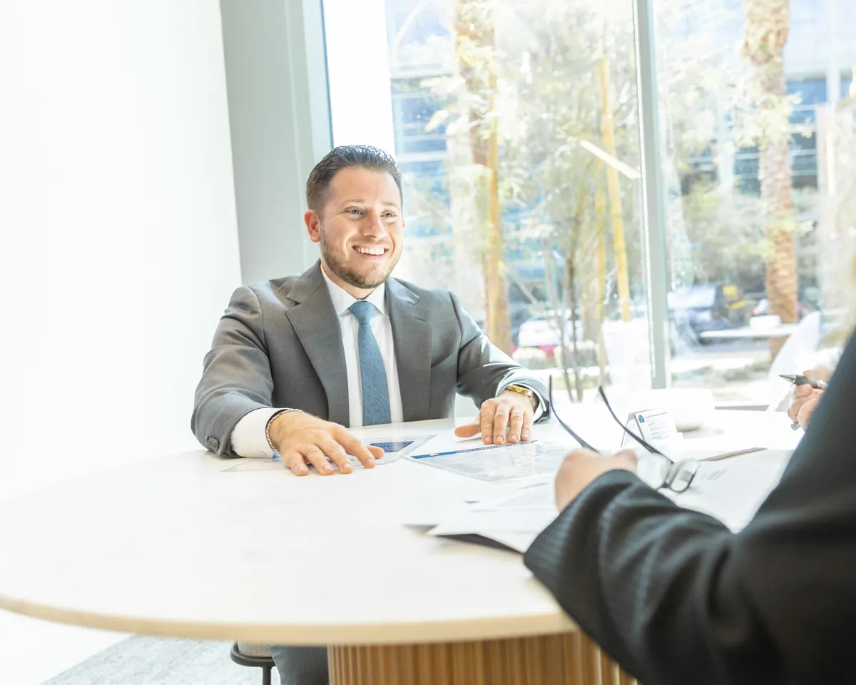 A Fullerton advisor meeting with a client beside the office windows